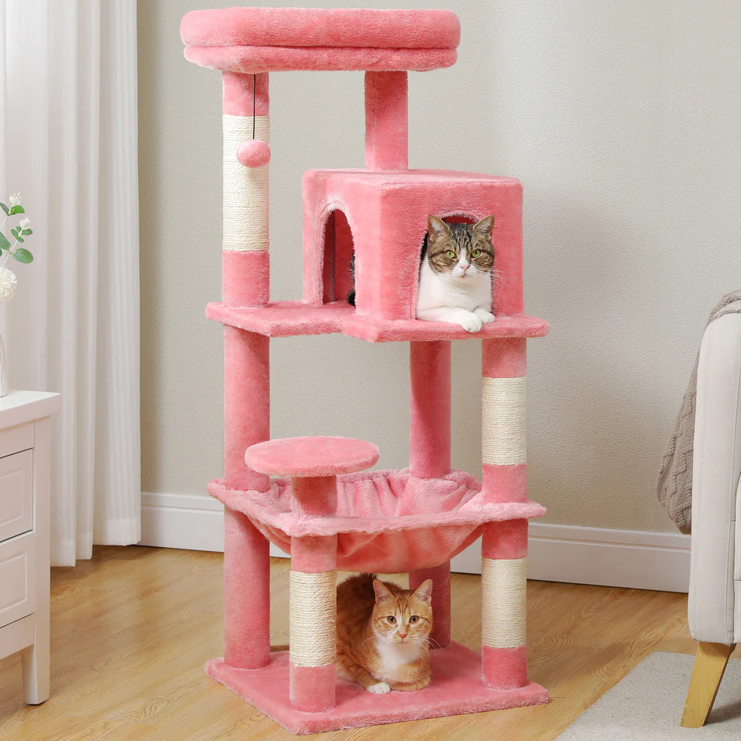 Pink cat tree with two cats on a wooden floor.