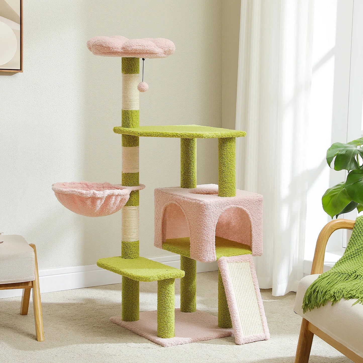Green and pink cat tree in a room with a plant and chair.