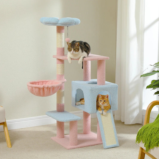 Cat tree with multiple levels and a cat sitting on top in a room with light-colored walls and a plant.